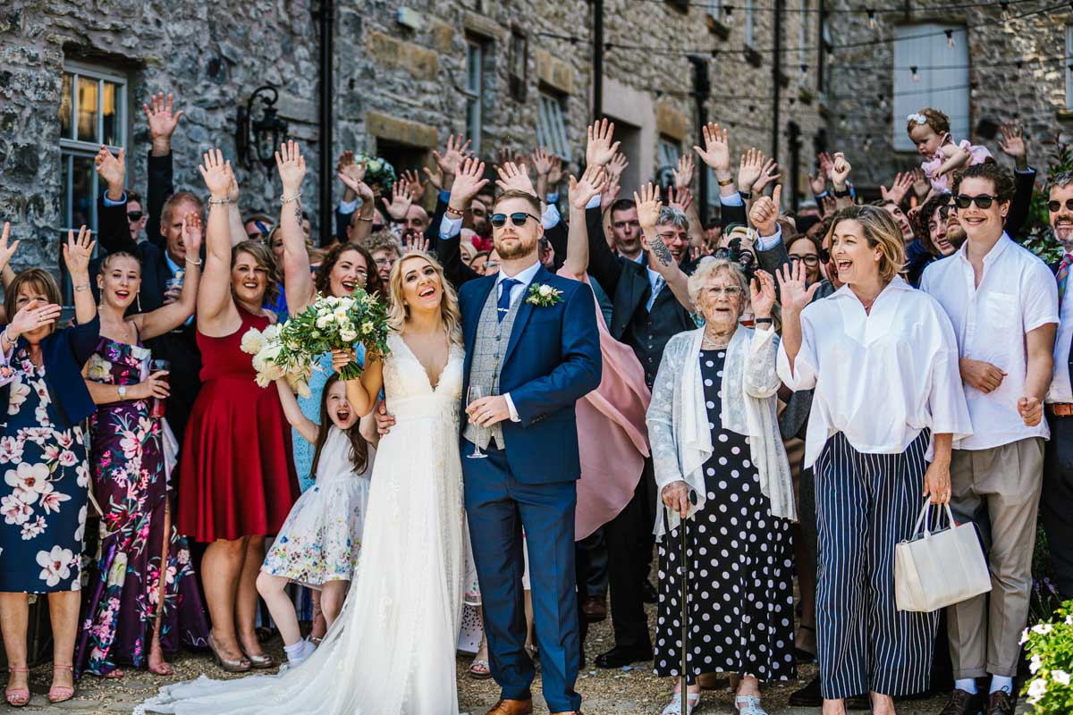 wedding guests outside summer sunshine smiles Holmes Mill 