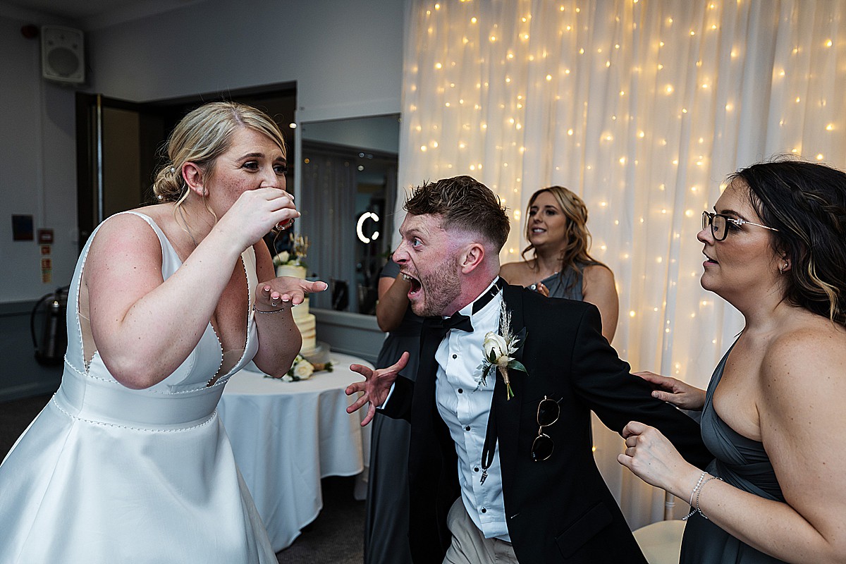 bride drinking a shot with family and friends Stirk House Luxury hotel Wedding