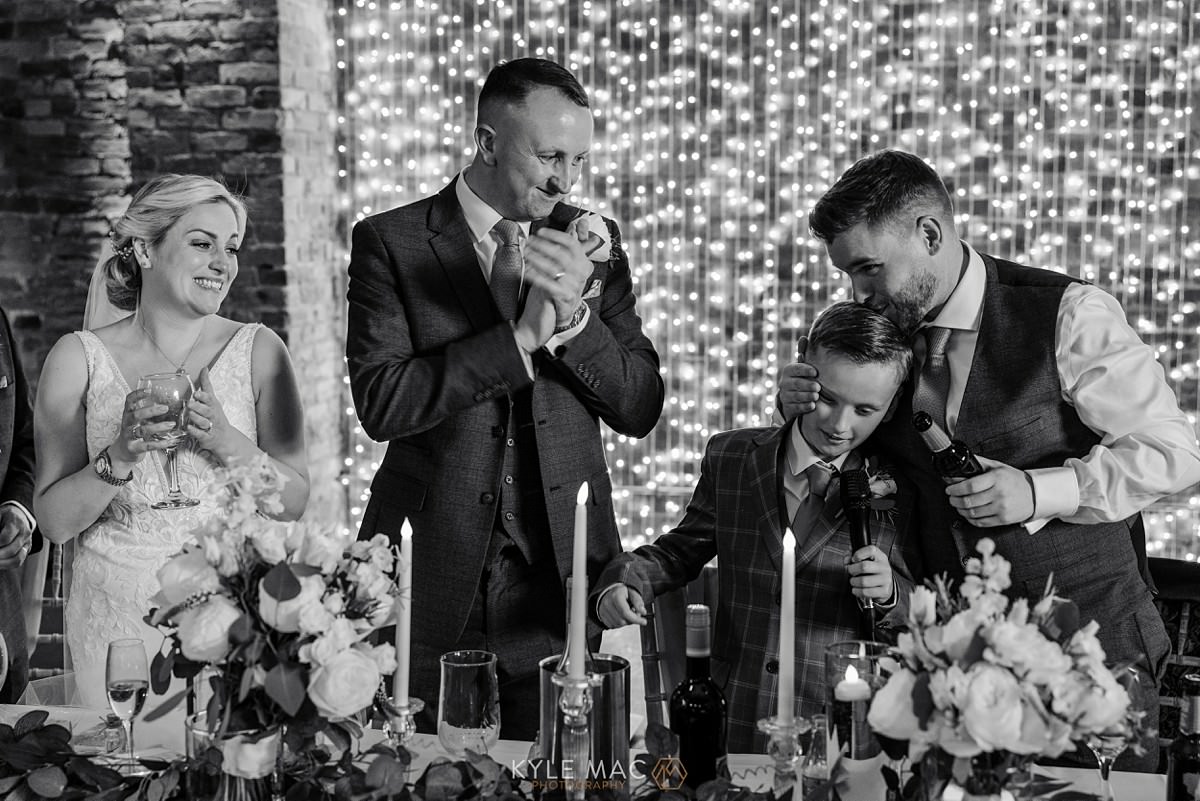 wedding guests bride groom kissing The Barn at Morleys Hall 