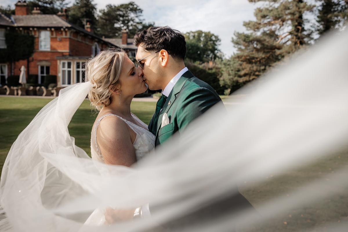 bride groom kissing on the gardens of Bartle Hall