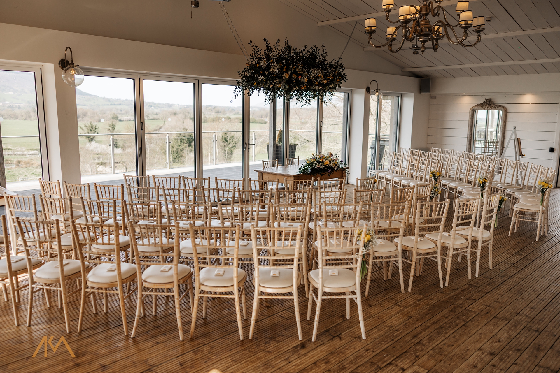 bashall barn ceremony setup chairs hanging flowers